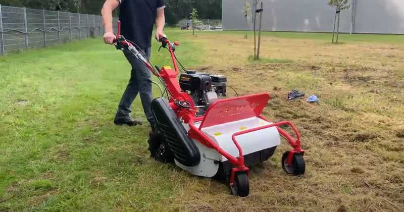 a person cutting the grass with a machine