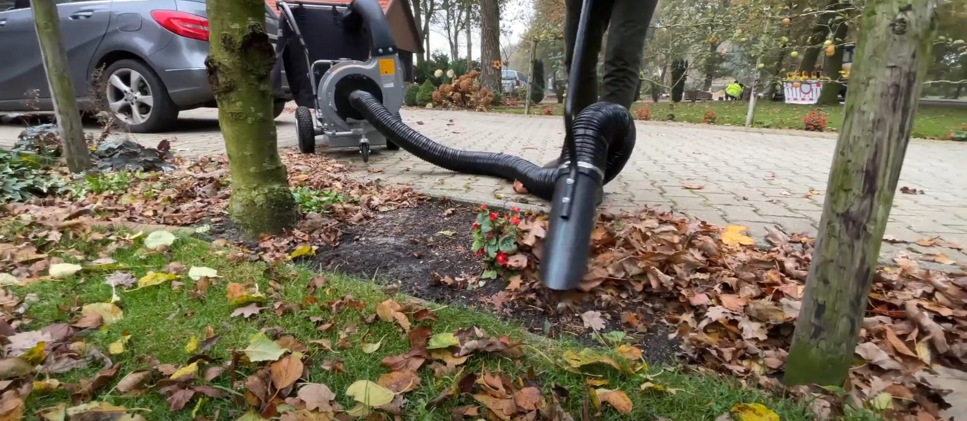 a person using a machine to clear leafs that have fallen