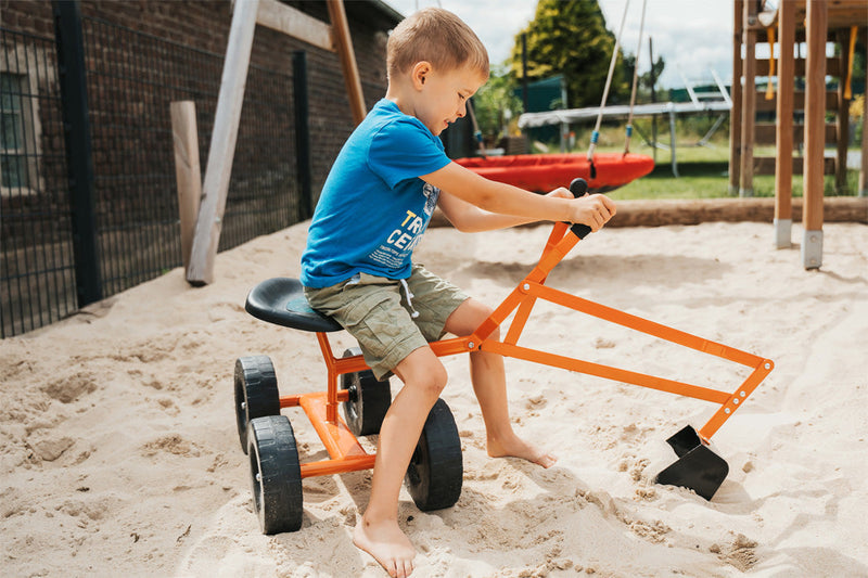 child playing outside with a toy excavator 