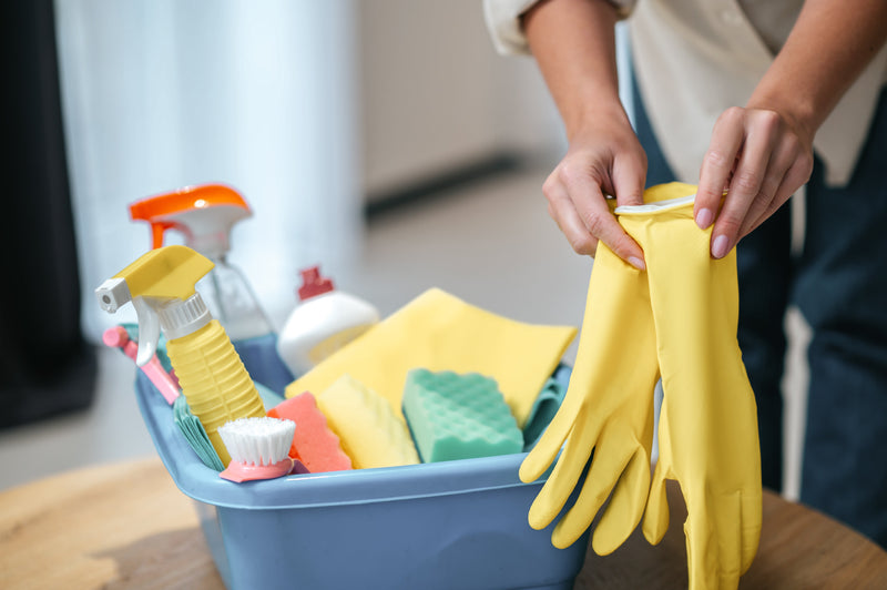 person preparing to clean with gloves and cleaning products